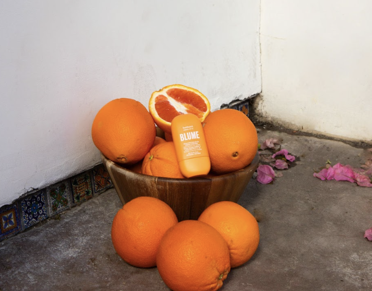 Blume Sunburst SPF 50 mineral sunscreen surrounded by citrus in aesthetic natural setting