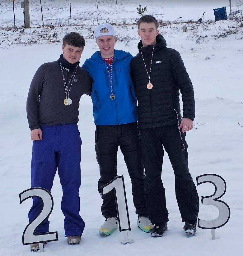 A group of men standing in the snow with medals
AI-generated content may be incorrect.