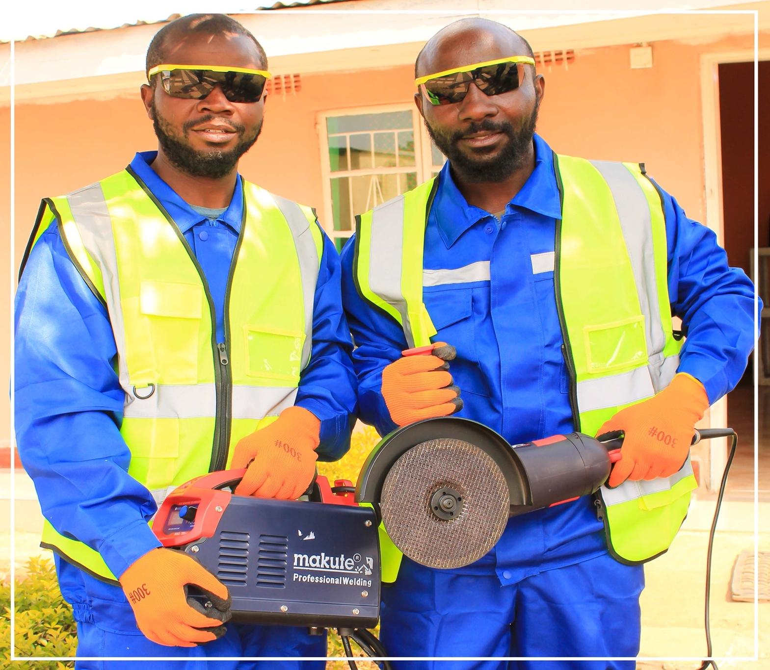 A group of men wearing safety vests and gloves holding a circular saw

Description automatically generated