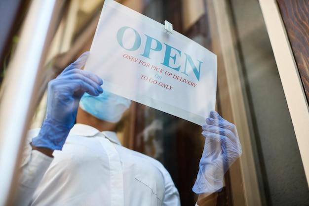 Mujer abriendo su establecimiento de comercio.