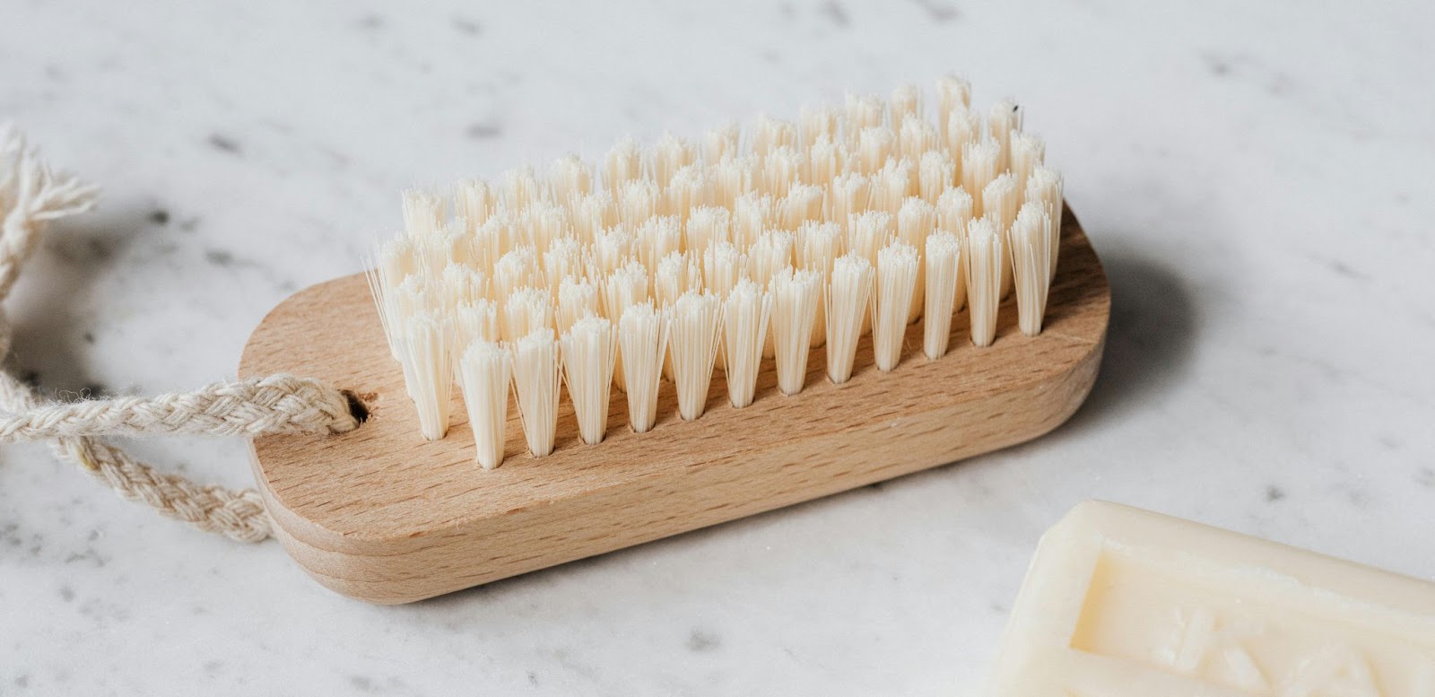 A typical nail brush for cleaning excess debris from nails is a rectangular, short brush with several rows of short, clustered bristles.