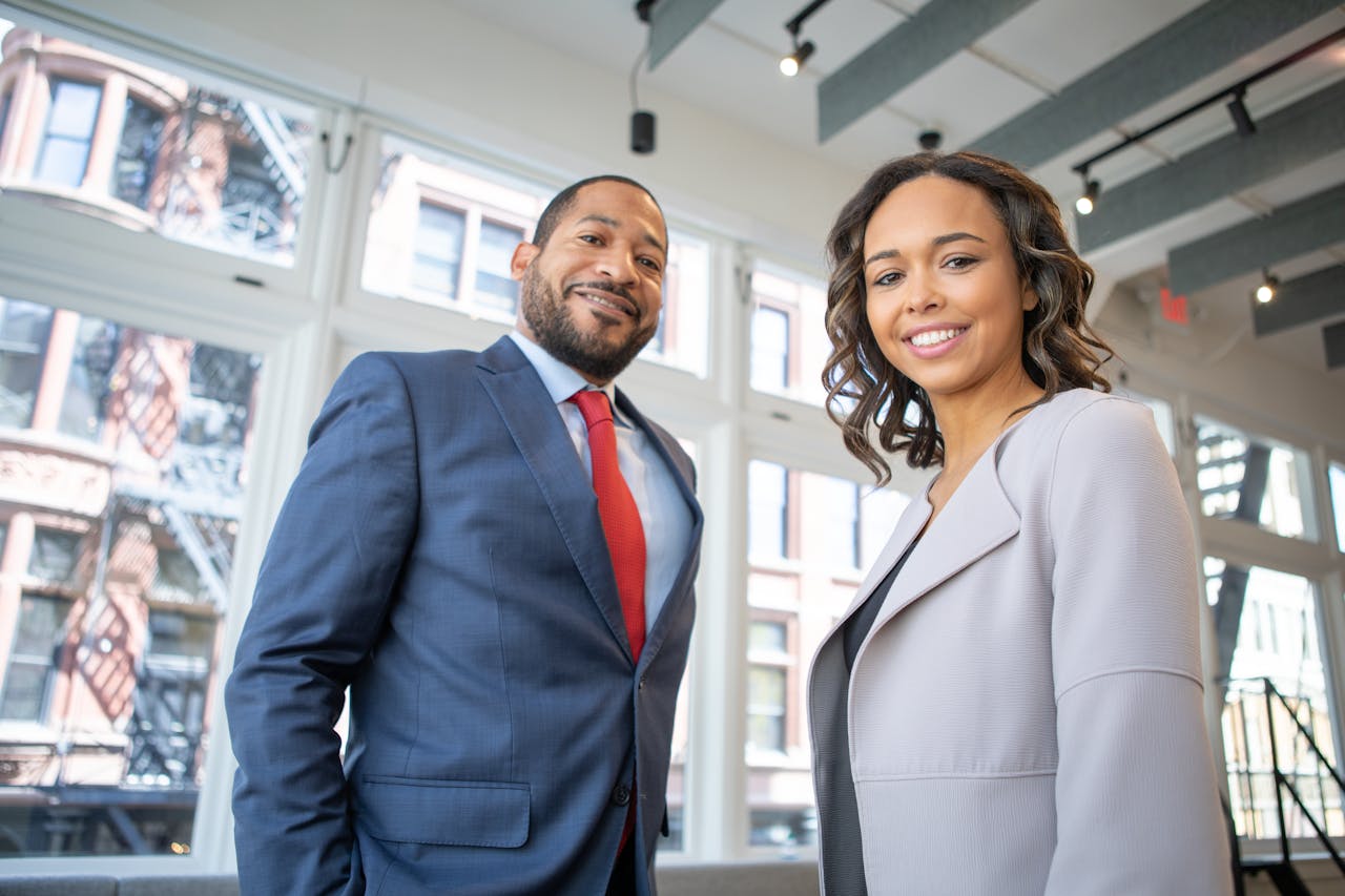 Two professional colleagues smiling confidently during an annual business review in an office 