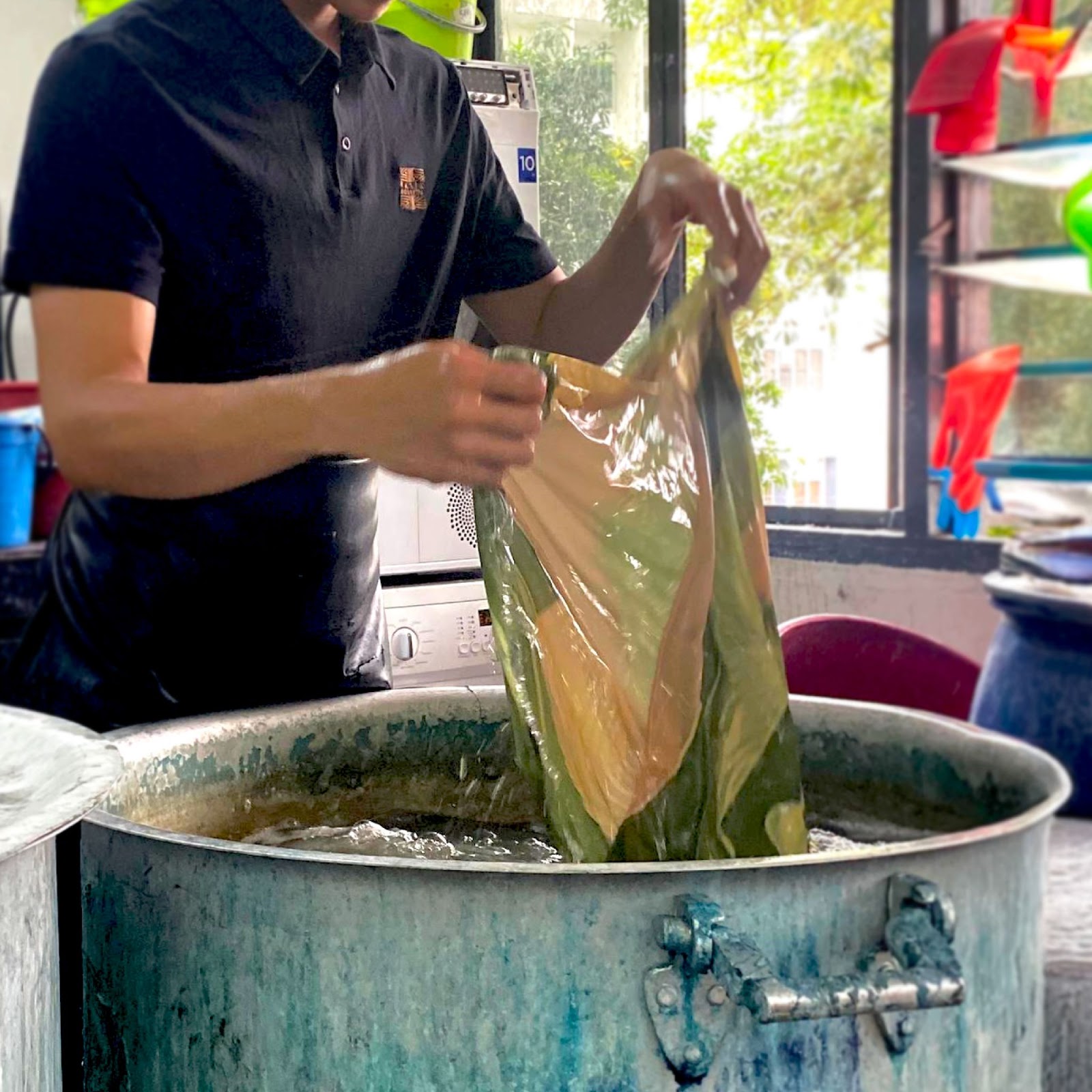 An image showing an artisan is boiling a batik fabric to remove the silicate