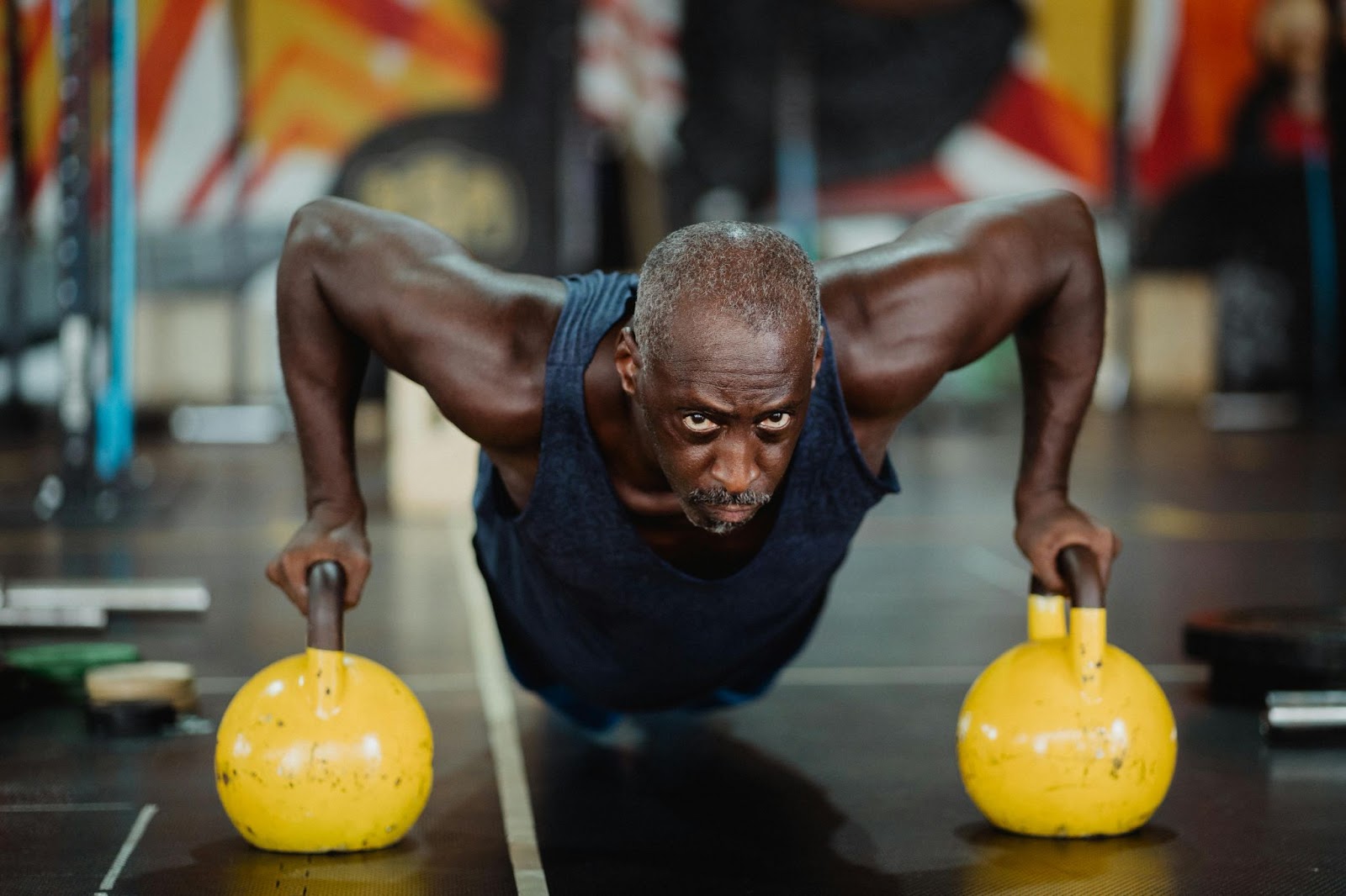 A senior man doing pushups in the gym