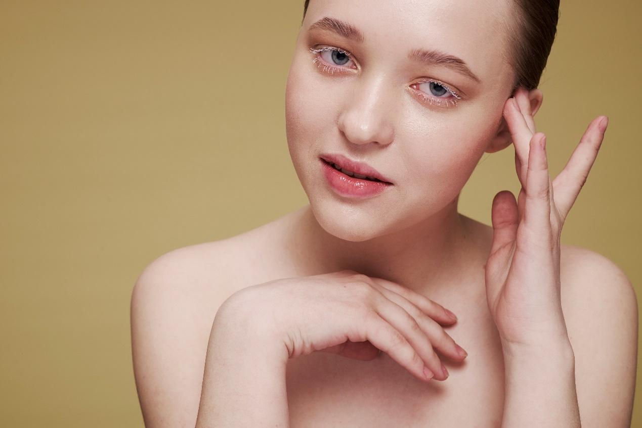 A person with her hand on her face

Description automatically generated