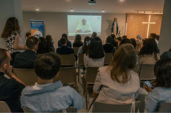 A group of people sitting in chairs watching a presentation

Description automatically generated