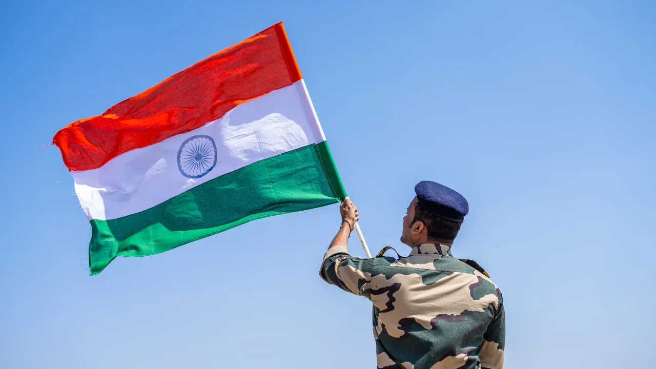 A person in military uniform holding a flag
Description automatically generated