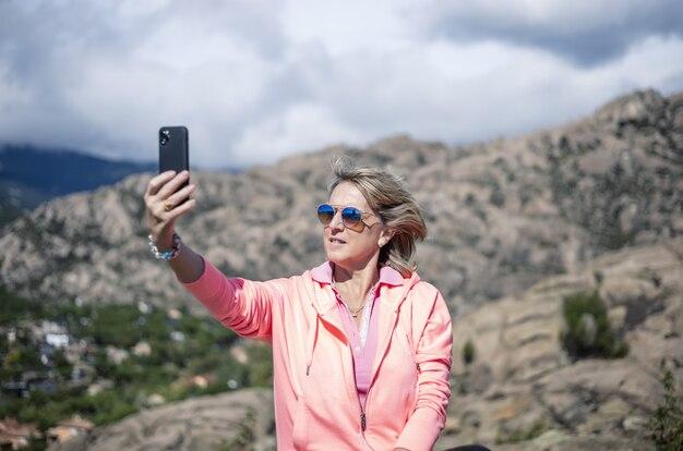 Female hiker using her phone and taking pictures of the beautiful view