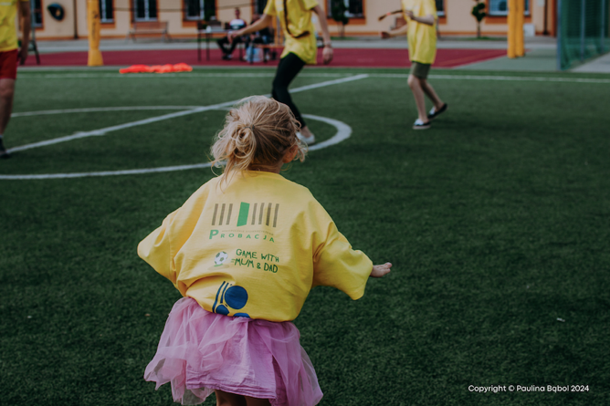 A child in a tutu on a field

Description automatically generated