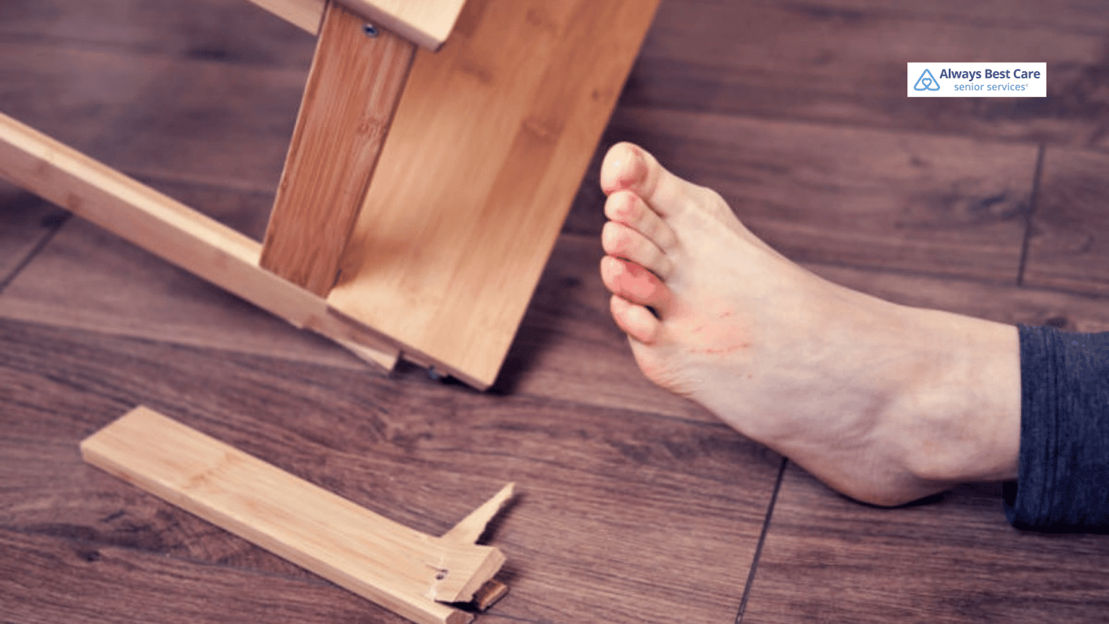 This image depicts a senior on the ground with a foot injury after falling due to unstable furniture