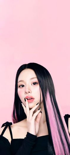 This contain an image ofTWICE's Chaeyoung with long black and pink hair holding her hand up to her face while posing for the camera