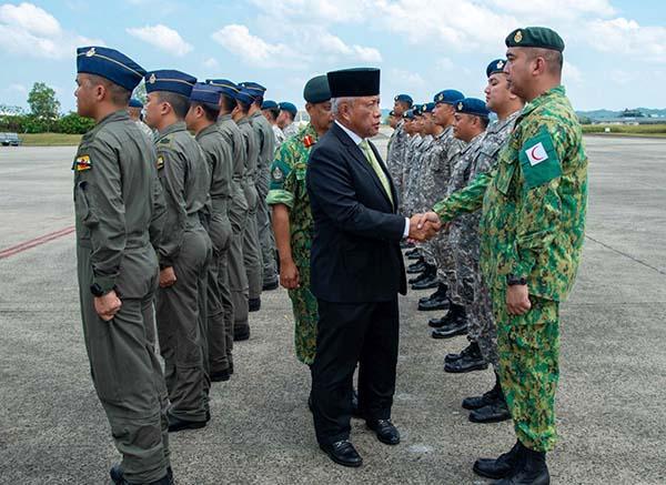 A person shaking hands with a group of soldiersDescription automatically generated