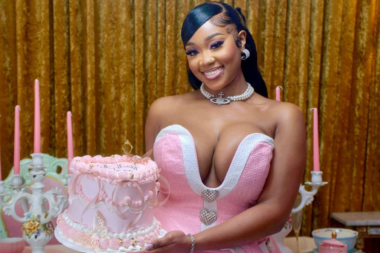 A woman in a pink birthday dress with a pink birthday cake.