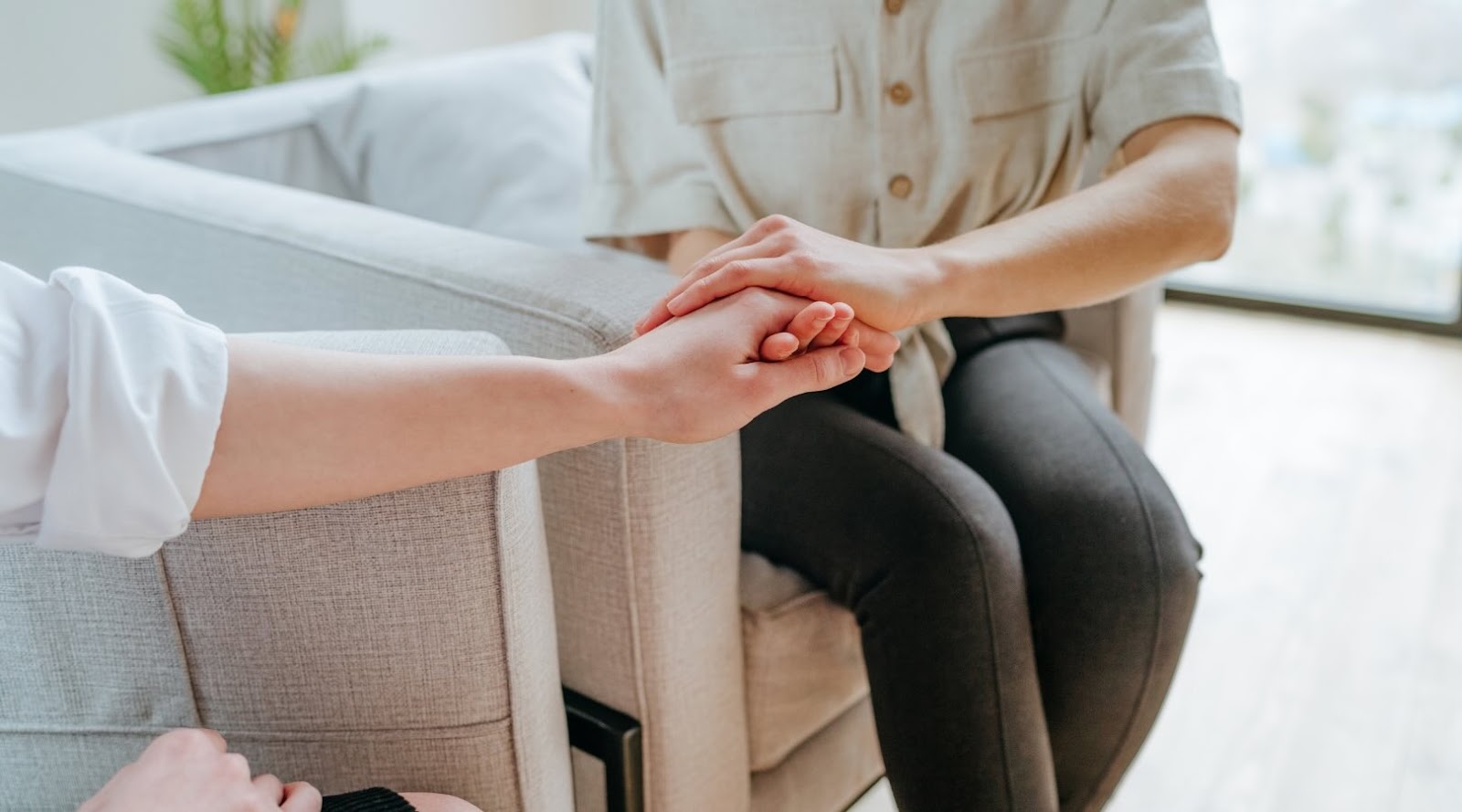 Two people holding hands in a gesture of emotional support during a nutrition consultation in Markham Toronto, symbolizing empathy and comfort in a therapeutic setting.