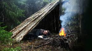 A man building shelter in a rain. Even though unplanned but serves as one of the  top survival hacks for rainy weather camping