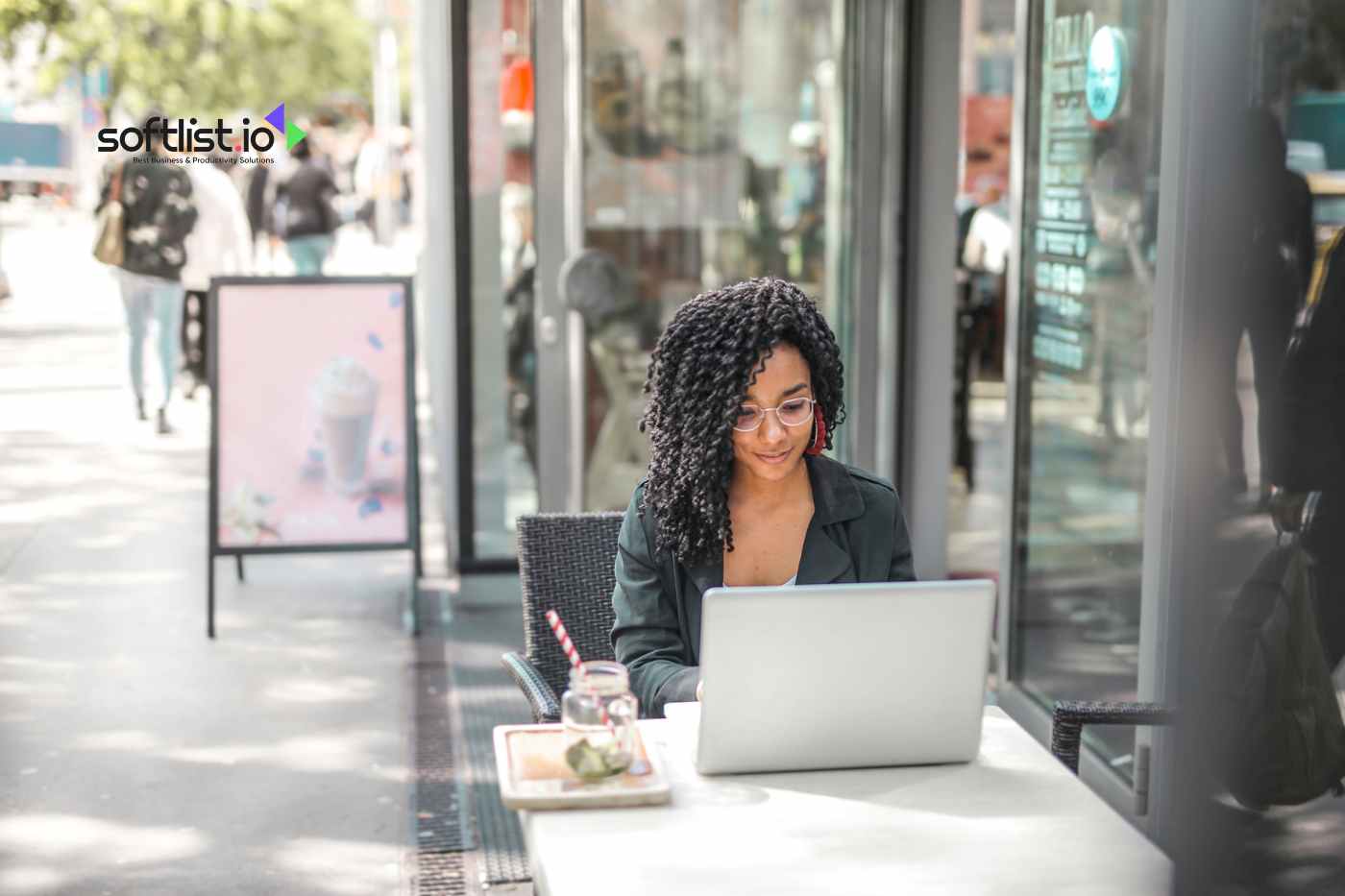 a woman is typing on her laptop outside