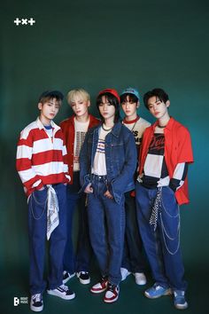 This contain an image of TXT standing next to each other in front of a dark green wall wearing red and white striped shirts