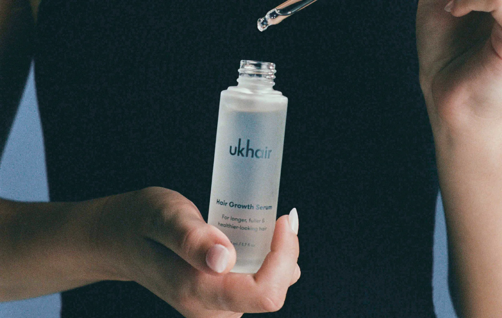 Persona con serum para cabello ukhair.