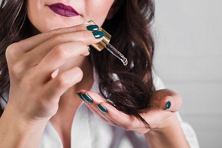 A woman's hair elegantly styled and taking a haircare with serum