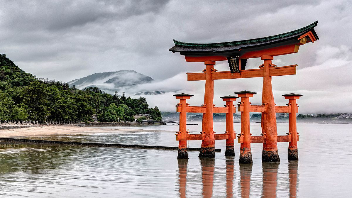 Itsukushima Shrine with its torii gate partially submerged in water.