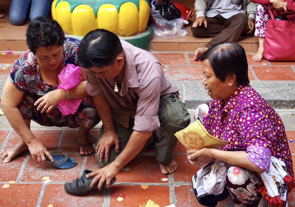 Người dân đang thực hiện phong tục “Đánh kẻ tiểu nhân” nổi tiếng ở Chùa Quan Âm (Ảnh: Sưu tầm internet)