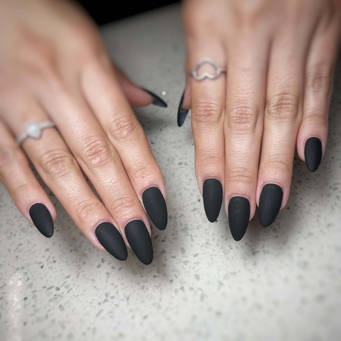 Close-up of a person's hands with black nails having Full Matte Black Nails
