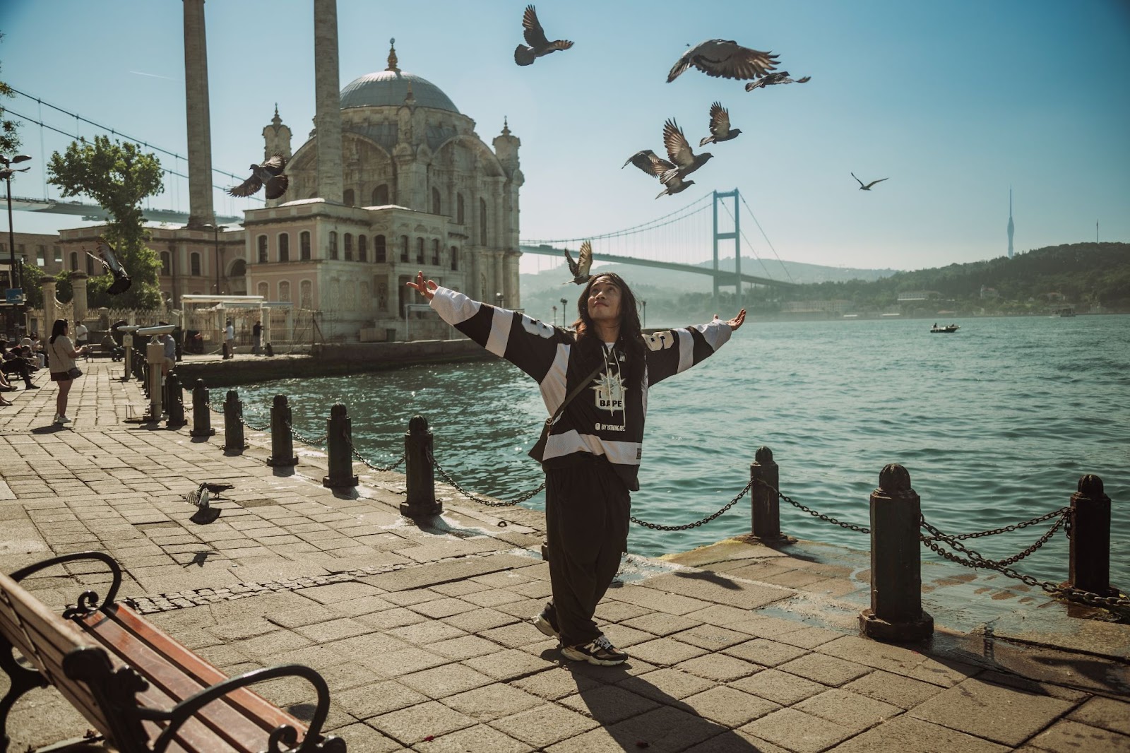 Open arms at Ortaköy — sunrise, streetwear, and wings in motion.