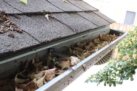 Clogged gutters contributing to roof leaks and water damage; essential maintenance for roof leak repair near me to prevent further issues.