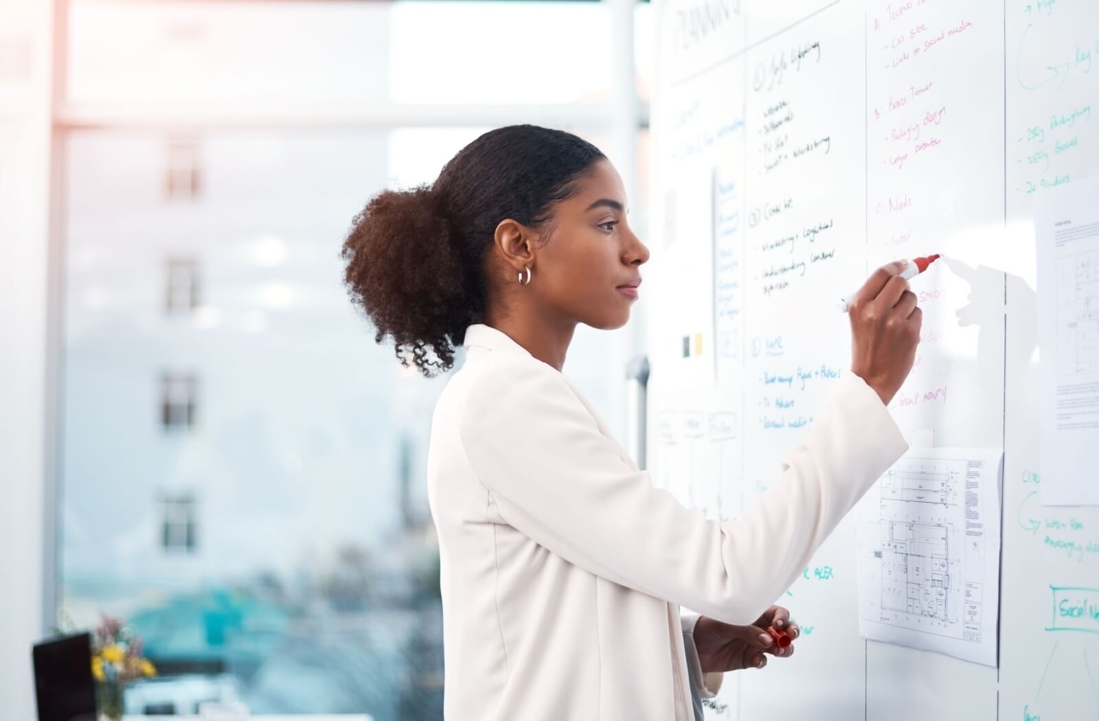 A young person brainstorming ideas for a new assisted living community on a whiteboard.