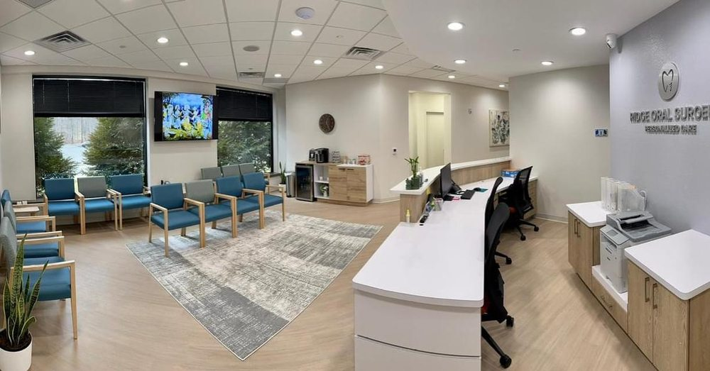 A spacious waiting room with comfortable seating and a reception desk at Modern Oral Surgery in Morristown, NJ.