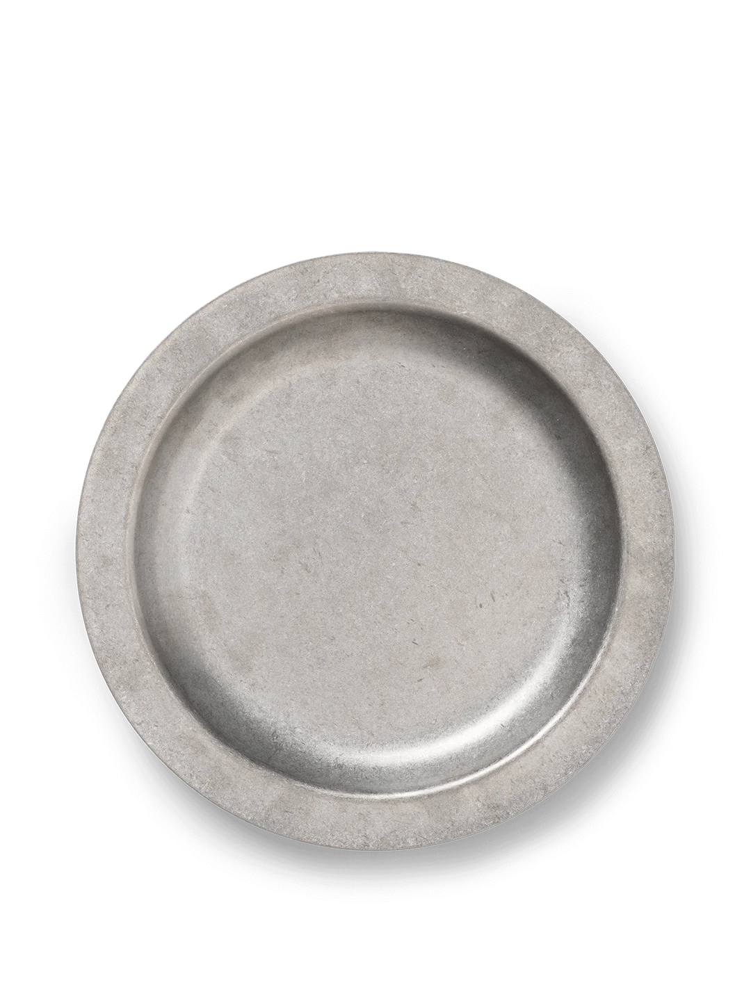 A Ferm Living Tumbled Plate with a smooth, matte finish in earthy tones, placed on a rustic wooden table, highlighting its minimalist and organic design.