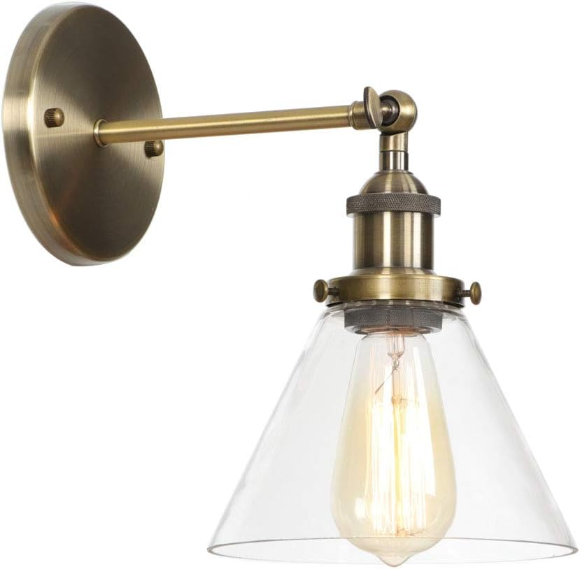 A brass wall-mounted light fixture with an exposed bulb inside a clear conical glass shade.