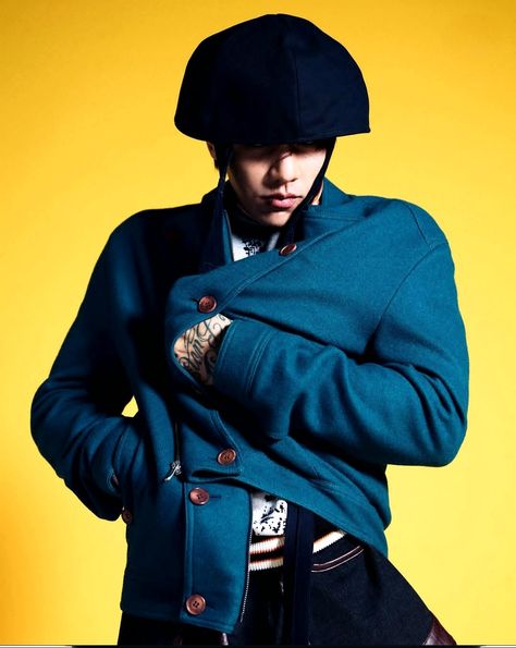 This contain DPR Ian in a blue coat and hat is posing for a photo with his hands on his hips