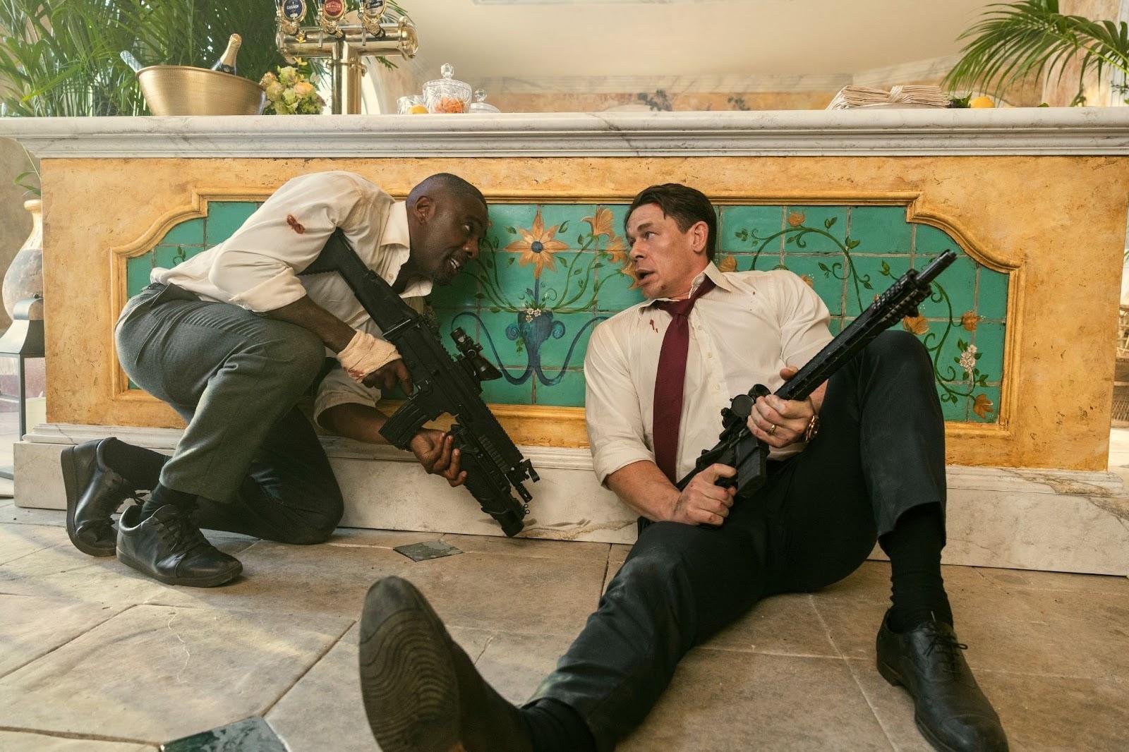 Two men holding guns and sitting on the floor

Description automatically generated