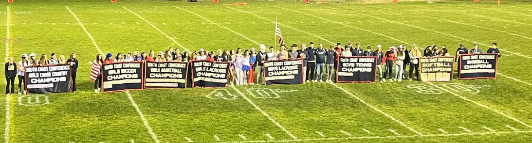 image of students on the football field holding banners