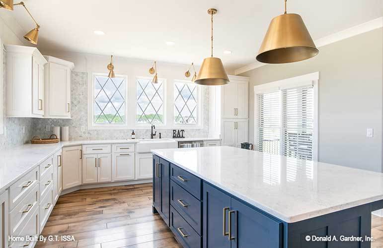 A closer look at the blue island topped with a white marble countertop.