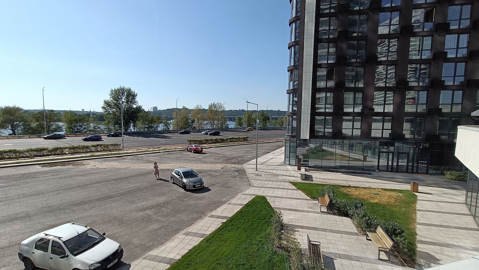 En el centro del banquillo. Puedes sentarte con una taza de café y admirar la vista del Dnipró hasta que el patio esté cercado y cuando el sol no brille. Y escucha el ruido constante proveniente de la autopista de seis carriles.