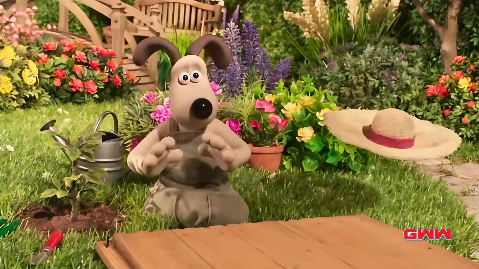 Gromit looking surprised while gardening, surrounded by flowers.