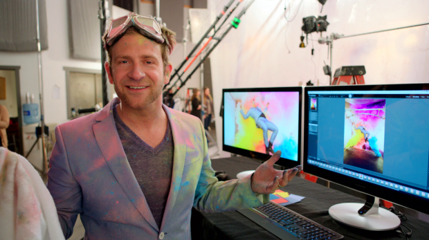 Chase Jarvis in same suit from last photo, standing in an editing bay with computer screens, editing the experimental photo mentioned in the previous photo above.