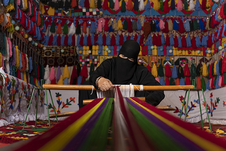 A Saudi woman weaving a rug in a shop - (Credits Dq Living Magazine)