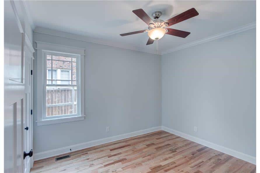 This bedroom offers a ceiling fan and hardwood flooring.