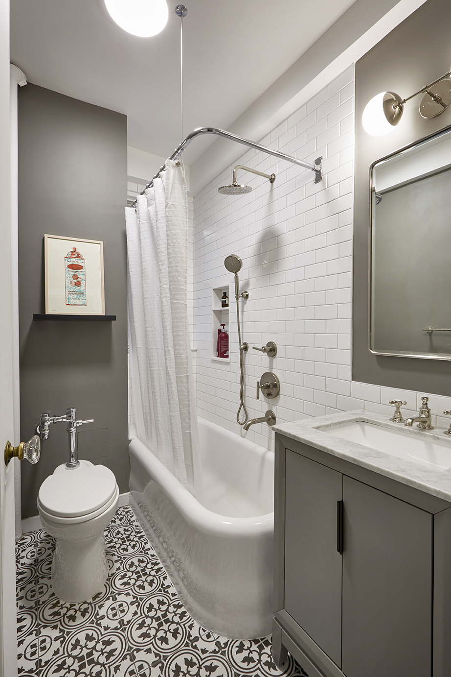 New York small bathroom with tub-shower combo, chrome fixtures, patterned floor tile, and a gray storage vanity