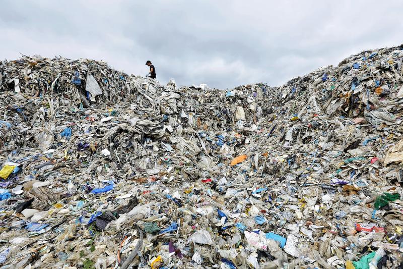 A huge pile of trash with a small human figure at top