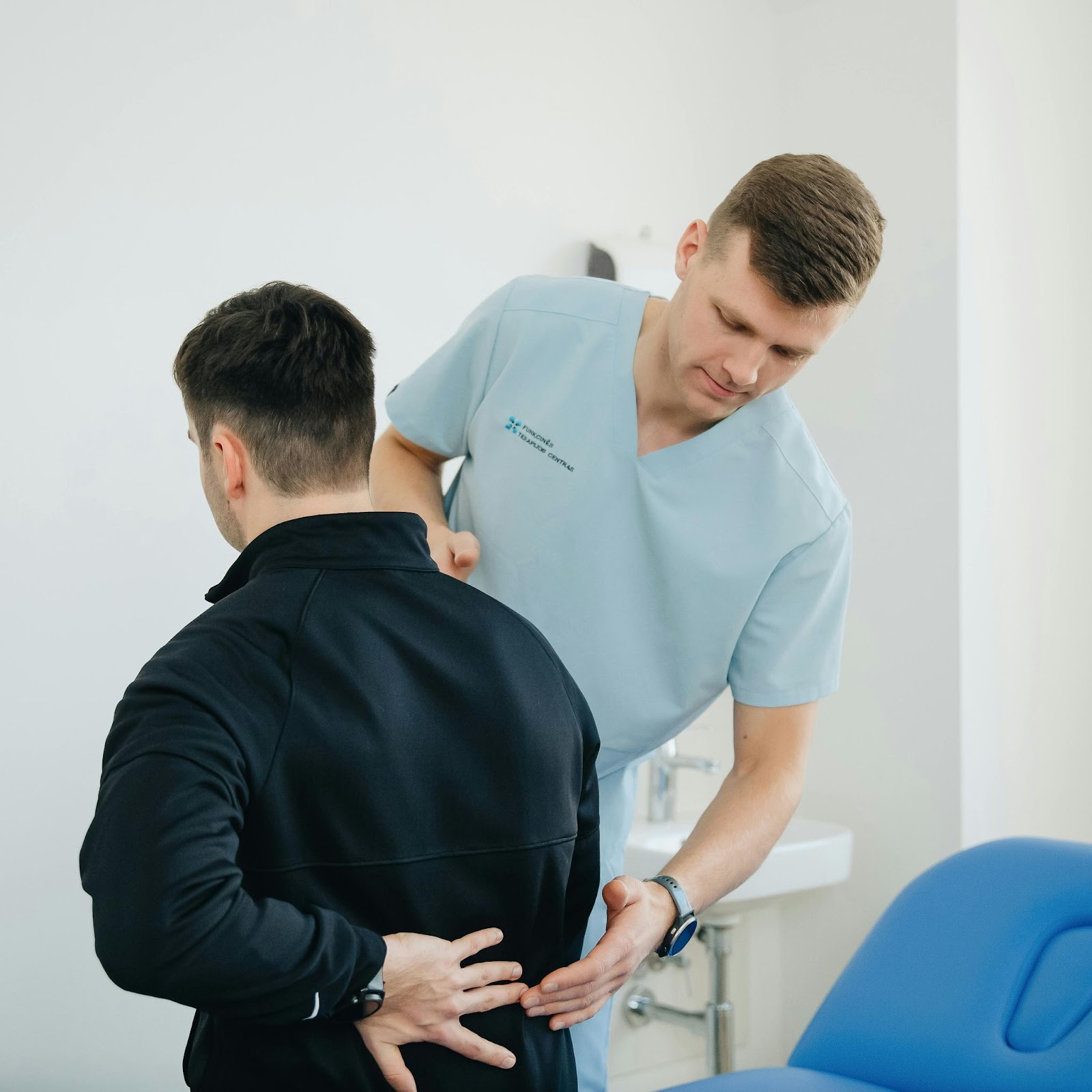 A doctor examines a man with muscle pain.