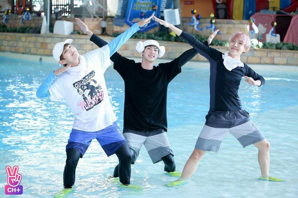 A still from the variety show ‘Run BTS’ that depicts three members of BTS playing in the pool and posing for a picture.