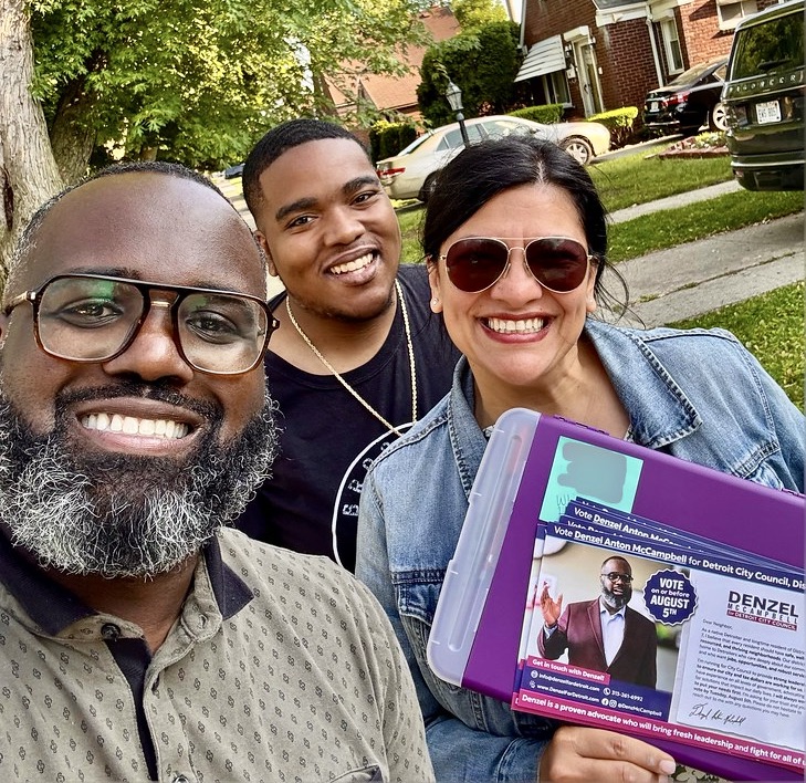 Selfie-style photo of Denzel McCampbell and Rashida Tlaib smiling with Denzel's election literature.