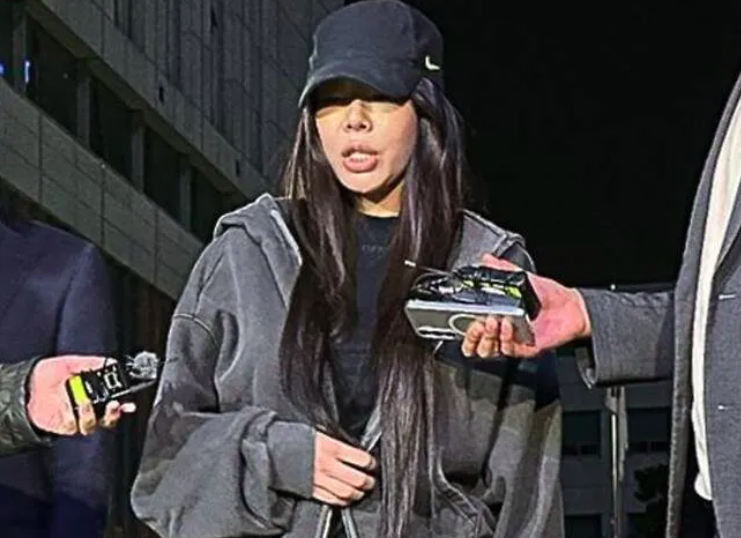 This contains an image of Jessi dressed casually in a zip-up hoodie and black cap