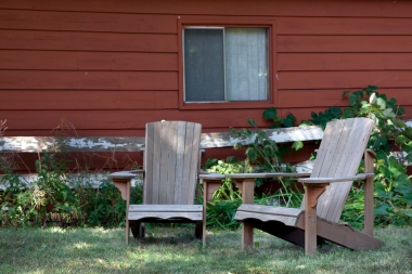 signs your outdoor living space is ready for a remodel older backyard area with wood adirondack chairs custom built michigan