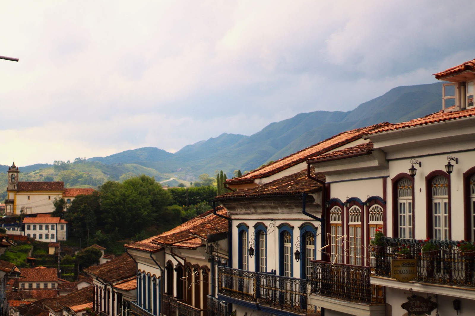 Várias casas antigas em uma cidade histórica com montanhas ao fundo mostrando um tipo de fotografia