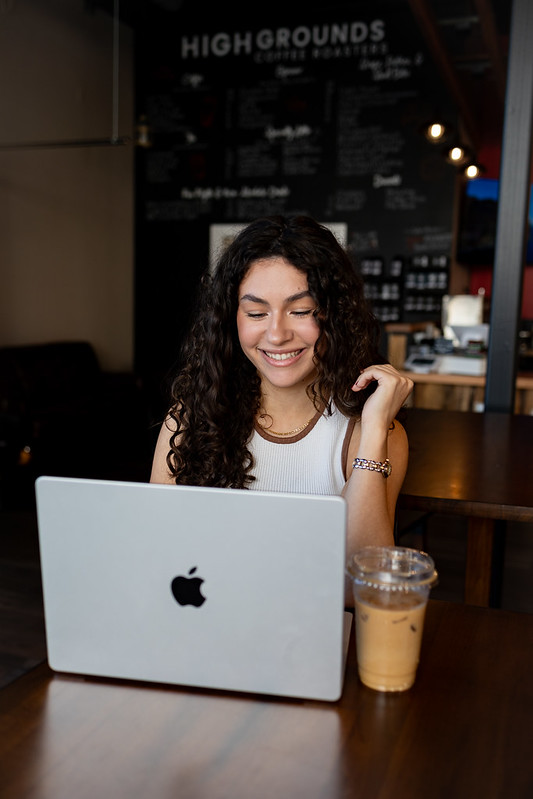 Student studying for an online psychology degree at a café with a laptop